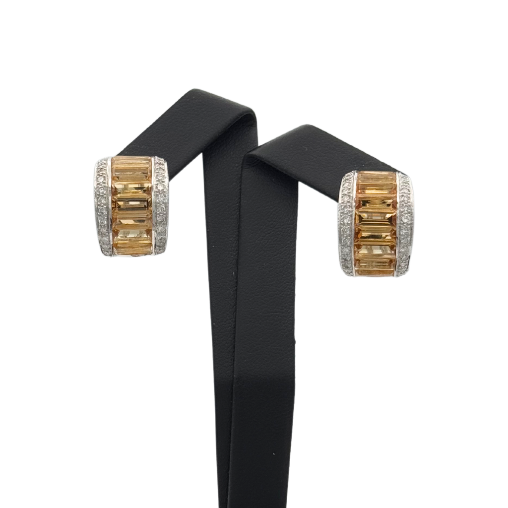 A pair of vintage 18k yellow gold earrings featuring rectangular yellow step cut citrines with pave set round brilliant cut diamonds on either side.