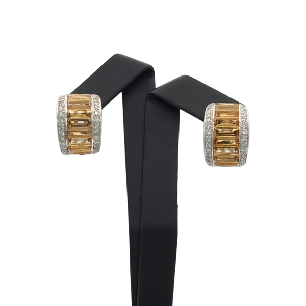 A pair of vintage 18k yellow gold earrings featuring rectangular yellow step cut citrines with pave set round brilliant cut diamonds on either side.