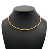 Gold necklace on a black mannequin bust against a white background